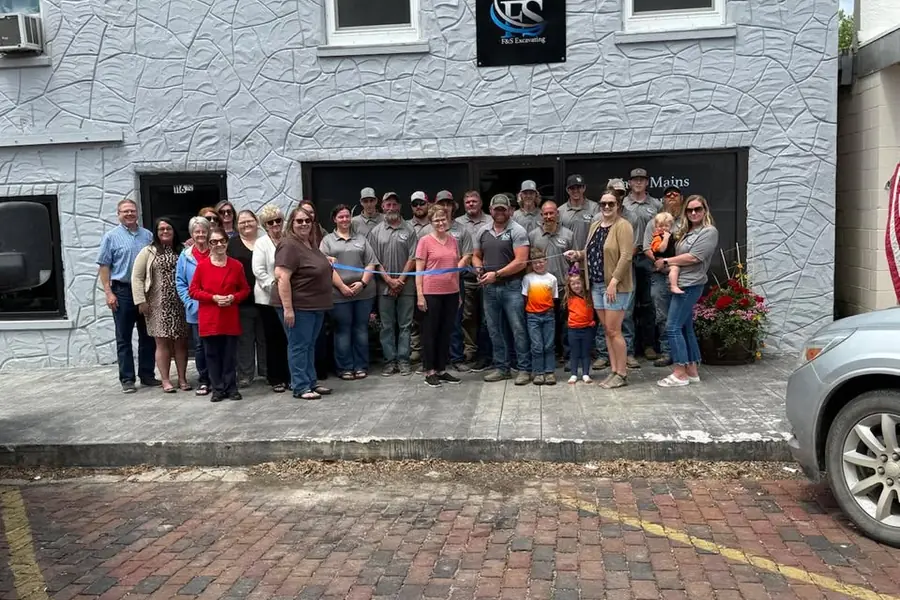 Group gathered outside a building for a ribbon cutting